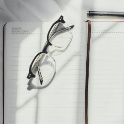 A photograph of a pair of spectacles on the open pages of a diary